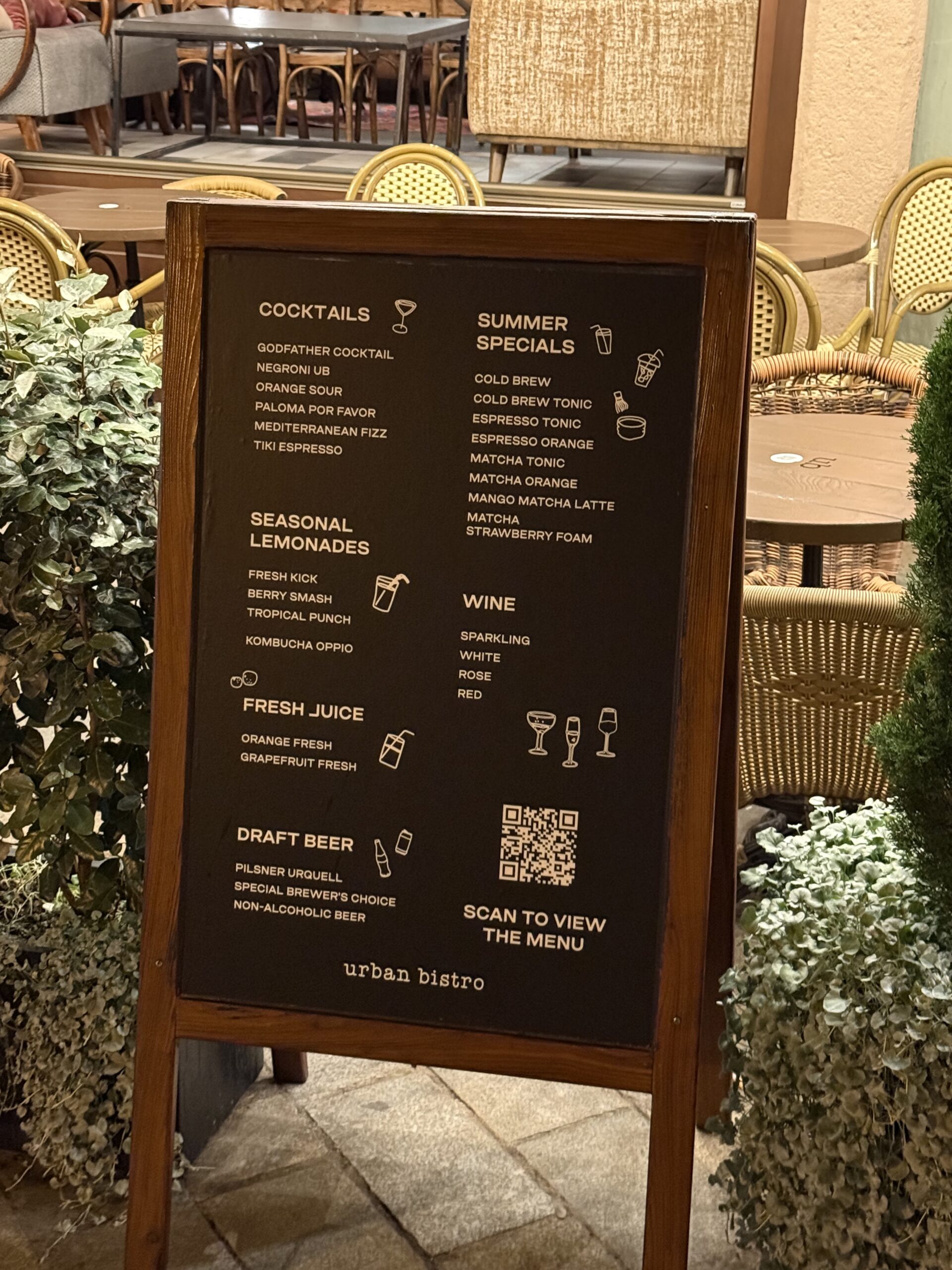QR code menu on a stand in front of Urban Bistro next to the drinks offer