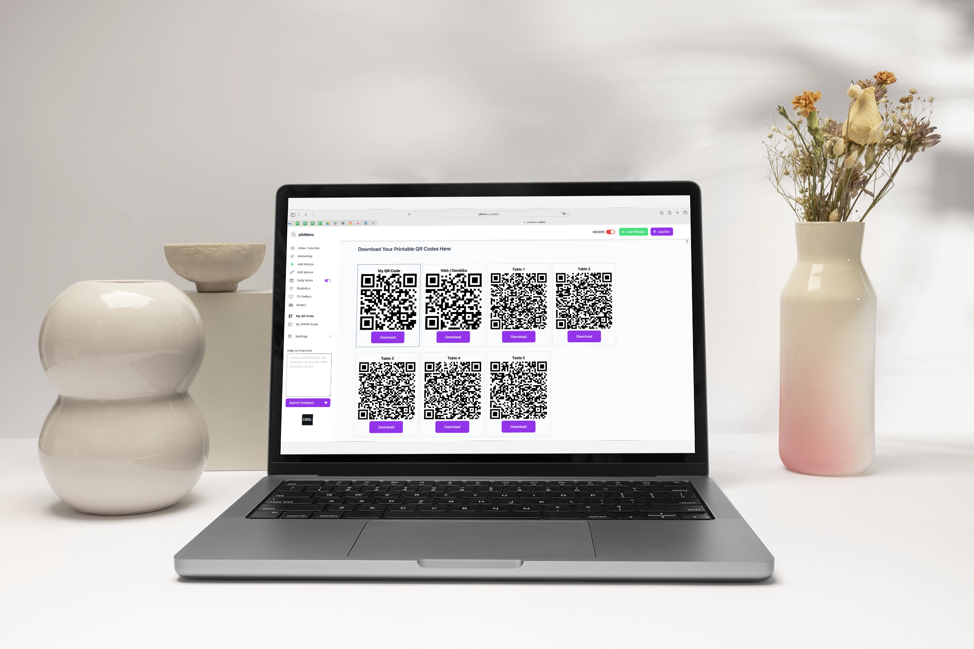 The pikMenu admin panel on a laptop screen displaying multiple downloadable QR codes for individual restaurant tables.