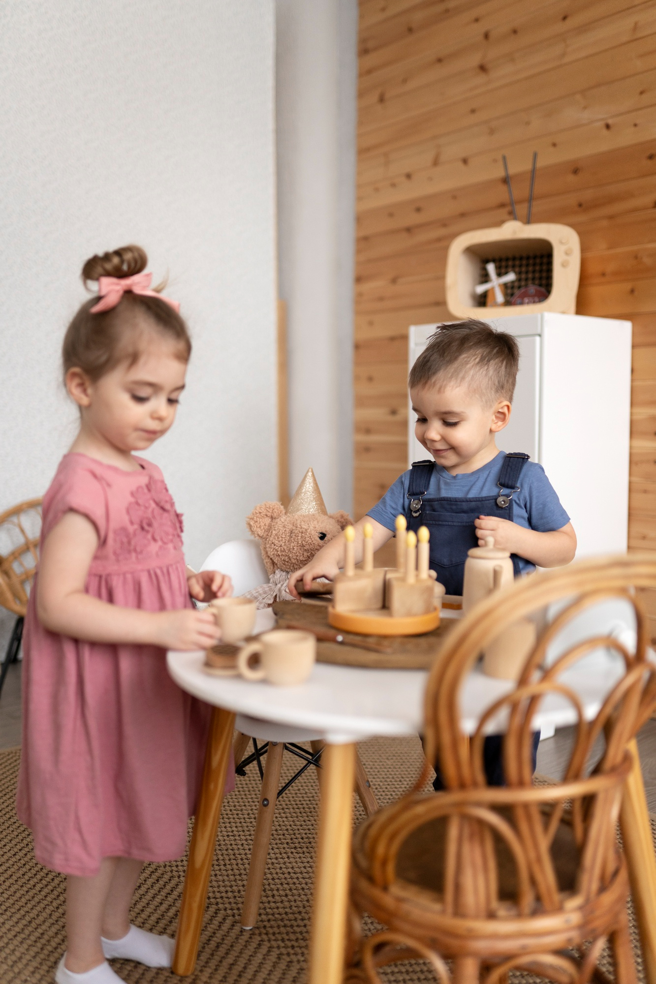 Deti sa hrajú s drevenými hračkami v útulnom detskom kútiku kaviarne.