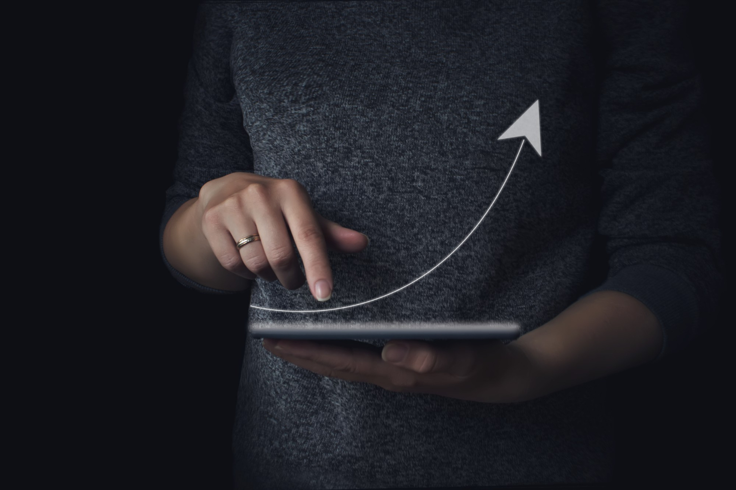 Person holding tablet with growth arrow symbolizing increasing sales using digital solutions